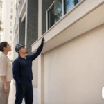 Fachada de condomínio com técnico fazendo inspeção.